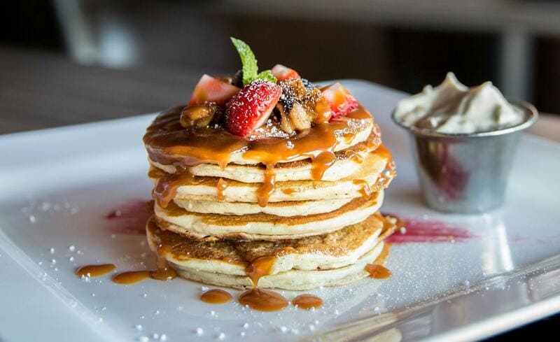 dessert inflammatoire composé de pancakes dégoulinants de caramel et bol de chantilly 